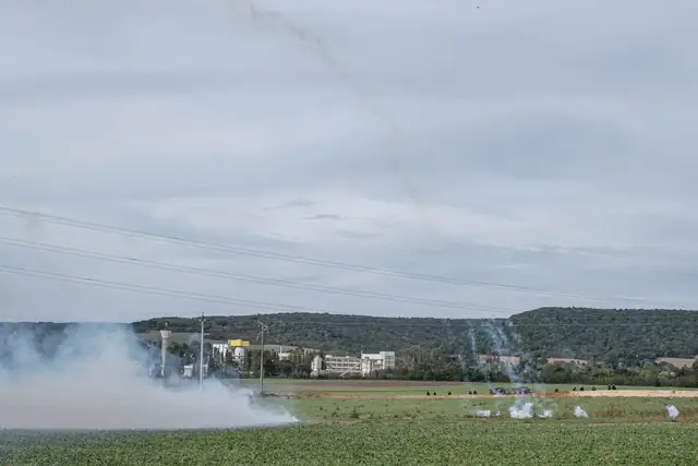 Nubes de gas lacrimógeno se elevan sobre el campo frente a la fábrica