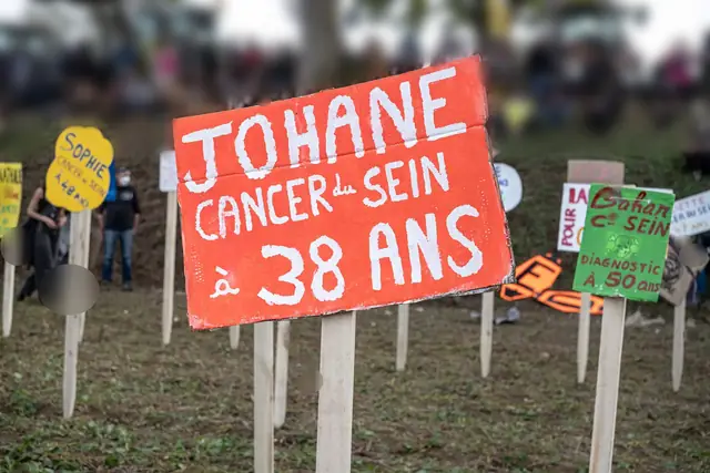 Un cartel rojo, «Johane, cáncer de mama a los 38 años» («Johane, cancer du sein à 38 ans»), clavado en el cementerio de la salud pública