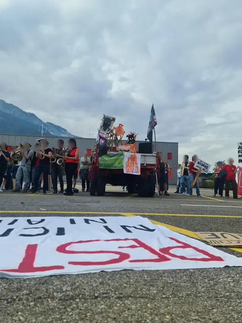 La charanga toca frente a la fábrica, detrás de la pancarta extendida en el suelo