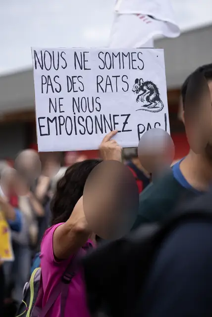 لافتة «لسنا فئرانًا، لا تسمّمونا!» («Nous ne sommes pas des rats, ne nous empoisonnez pas !»)